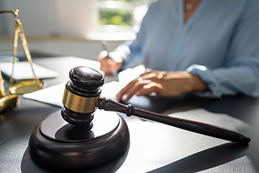 A judge's gavel resting on a desk.