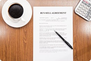 Contract between business owners detailing the procedures for buying out a partner's share in the company.