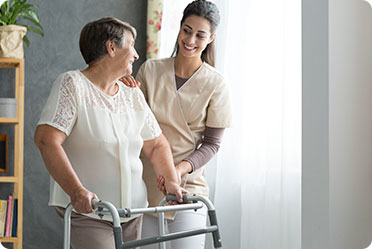 An older woman with a walker & young woman walking together