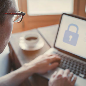 A man using a laptop with a padlock on the screen, symbolizing Business Protection. - Alex Kincaid Law